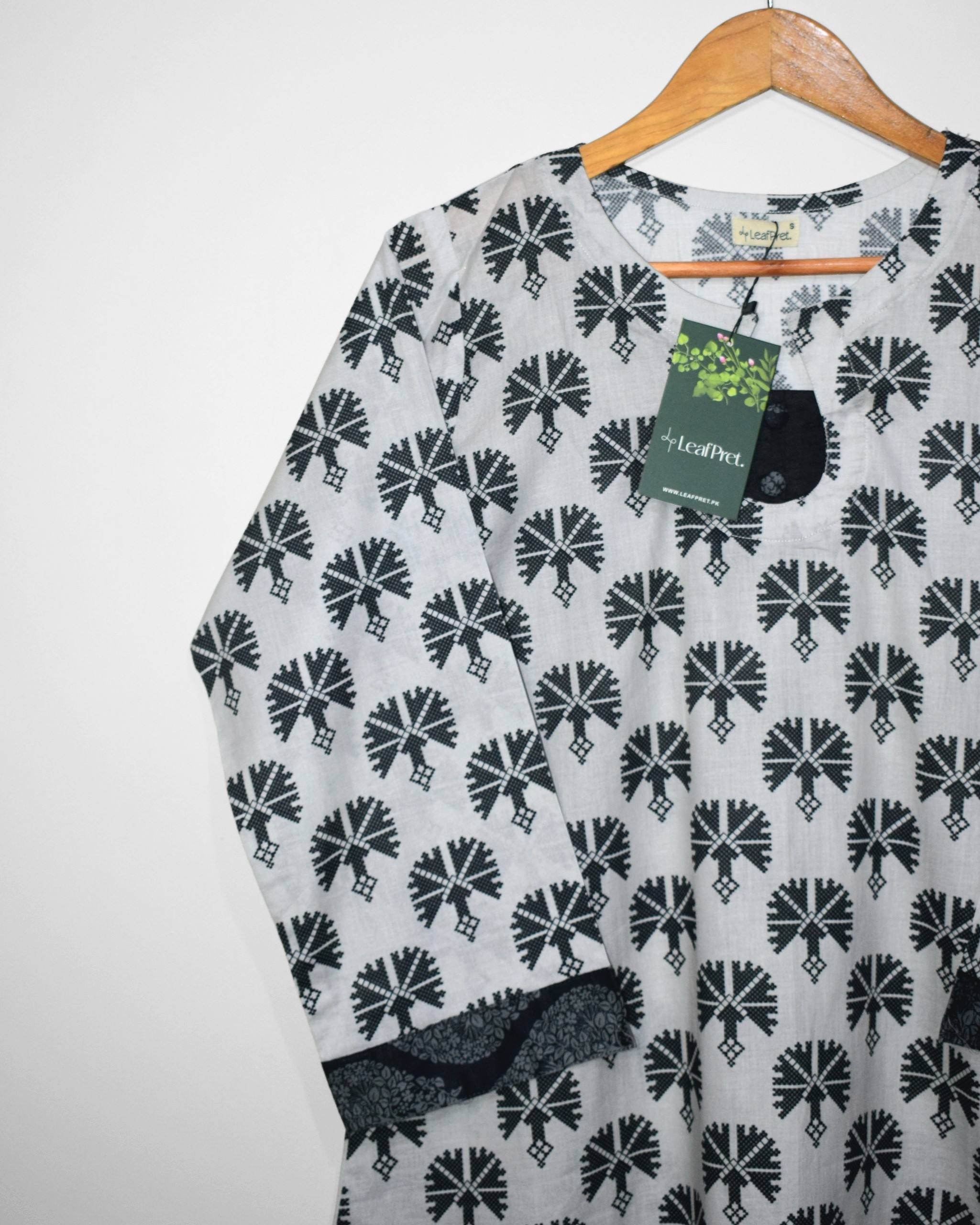 Close up view of monochrome muse lawn shirt showing black geometric floral digital print on white fabric with premium stitched detailing