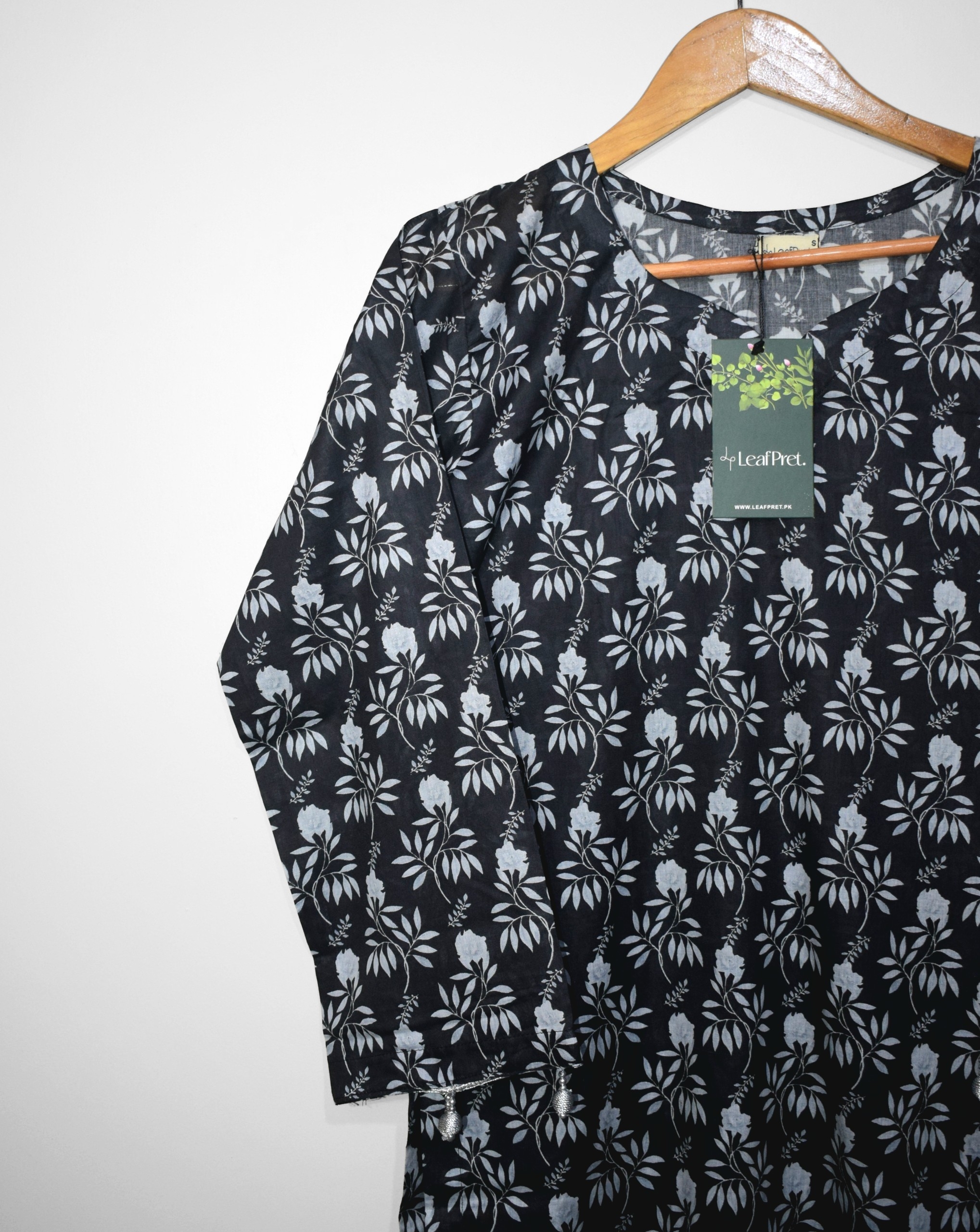 Closeup of BlackLeaf digital printed lawn shirt showcasing white botanical floral print on black lawn fabric with tassel sleeve detailing and soft summer texture