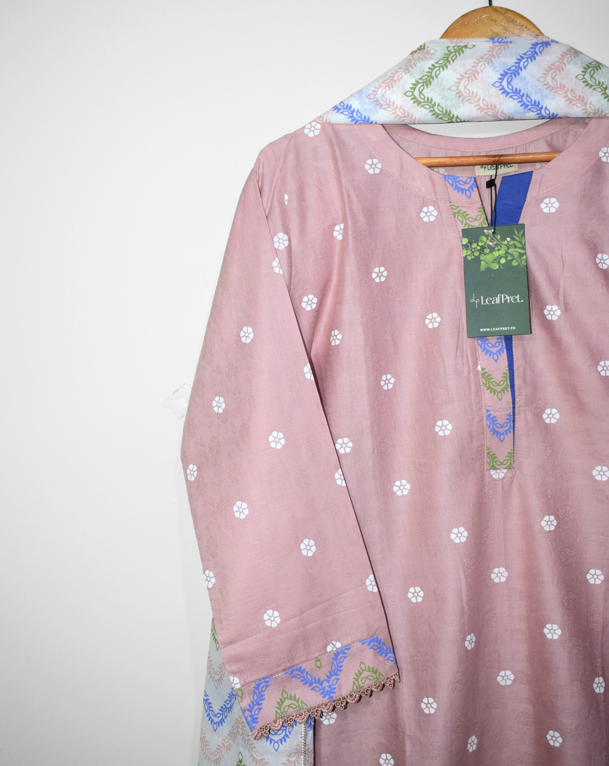 Close-up of Rosé Chevron neckline with elegant printed placket detailing on blush pink self jacquard lawn fabric and delicate floral screen print motifs.